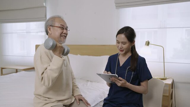 Professional Asian woman nurse physiotherapist using a dumbbell for workout exercise for physical recovery of muscles and bones of a senior man patient in hospital bed. Healthcare and medical concept.