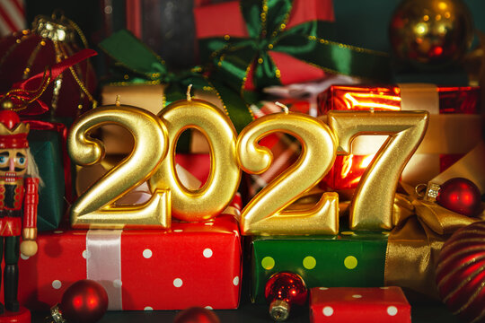 Golden numbers 2027, Christmas balls,  nutcracker and elegant red and green gift boxes.