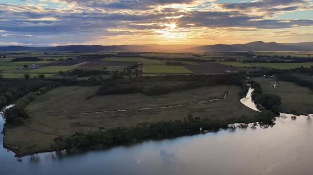 Aerial footage of the Clarence River and farmland in the warm evening light on Palmers Island, Yamba, New South Wales.