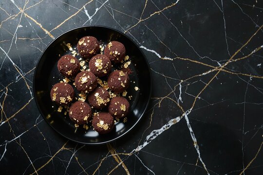 Gourmet Dark Chocolate Truffles Gilded with Edible Gold Leaf Flat Lay
