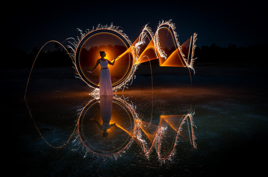 Woman posing for light painting photos Reflection in the water