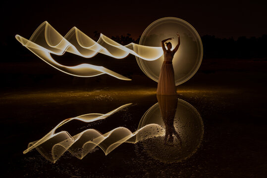 Woman posing for light painting photos Reflection in the water