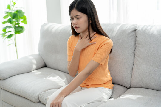 Asian woman put on neck due to a sore throat. female tonsillitis causes a inflammation. treated by taking water, taking antibiotics, consult a doctor, virus, corona virus, Influenza, flu