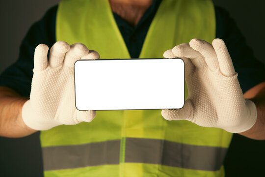 Mockup image of a worker holding a smartphone with white screen