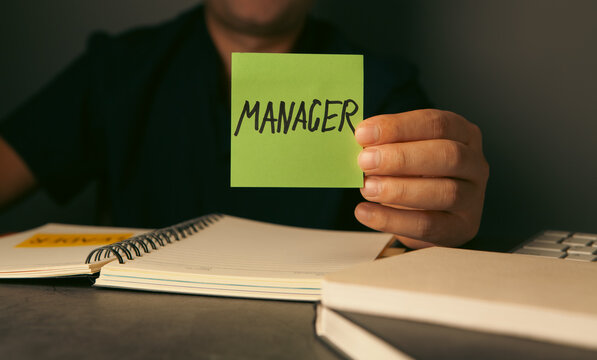 MANAGER word on green sticky note in hand, business concept