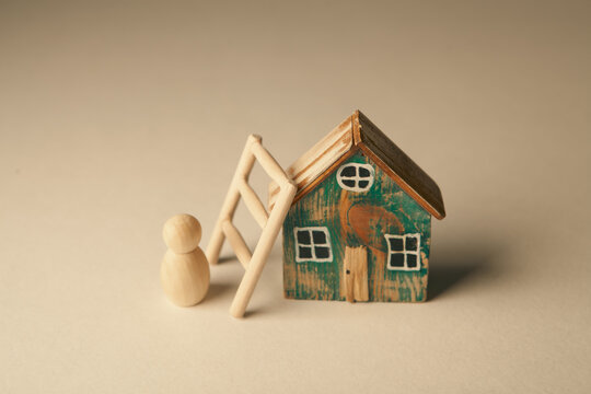 Mortgage concept. Wooden figure of a man and a ladder.