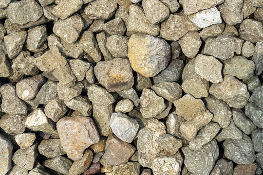 High angle view of crushed gravel stones ballast texture background, perfect for construction material, railway track, landscaping, architectural design, and industrial pattern concept.