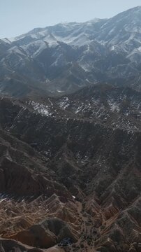 Wide aerial footage of Skazka Canyon with rugged red sandstone ridges, dry gullies and sparse shrubs in Issyk-Kul Region, Kyrgyzstan