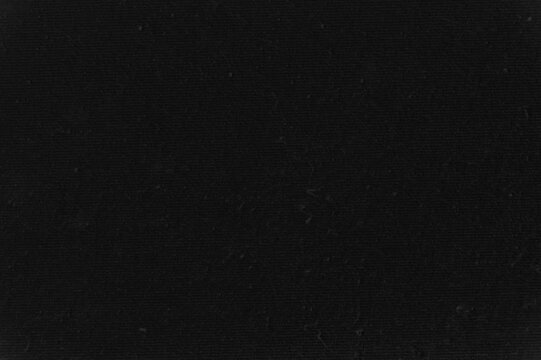 The dark solid texture of the black fabric with a fine pile.