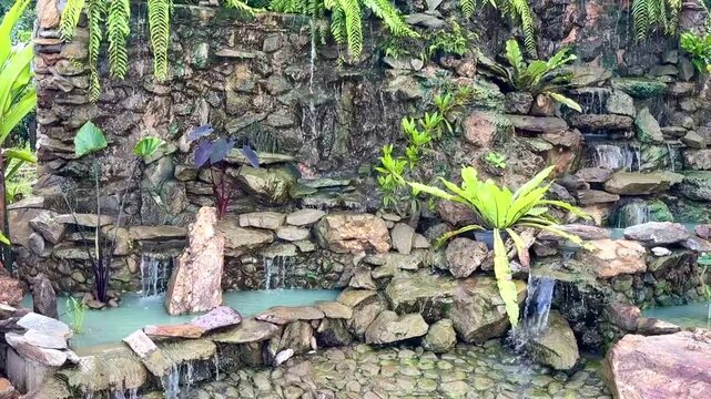 Waterfall on the racks wall in the mini garden , video.