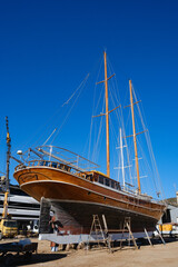 Two masted timber sailing vessel ashore with a ladder against the hull © Bugra Kaan Ersoy