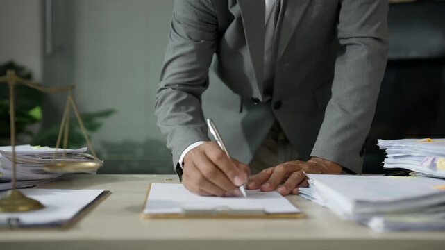 Businessman Reviewing and Signing Financial Documents at Office Desk