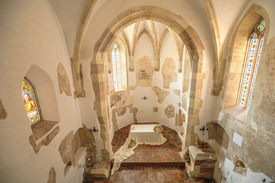 Corvin Castle church chapel interior featuring gothic architecture, intricate stained glass windows, and a modest altar, highlighting historical beauty and spiritual traditions in Transylvania Romania