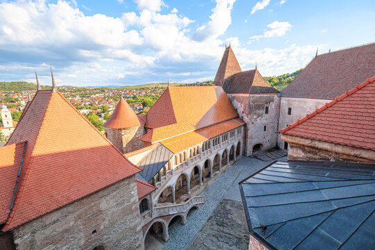 Corvin Castle in Hunedoara, Romania, presenting its historic courtyard and traditional tiled rooftops, showcasing the medieval architecture of this Transylvanian landmark in Romania