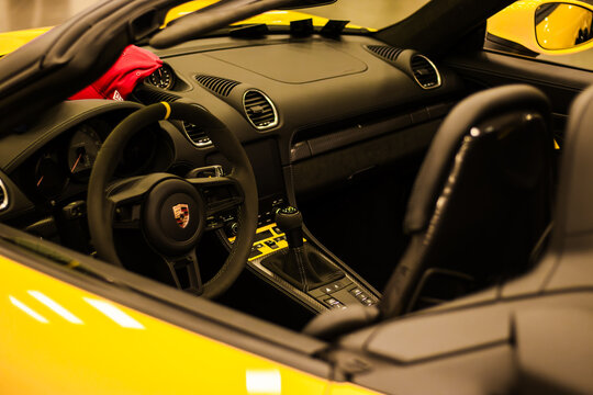 Krakow, Polska - September 06, 2026: Yellow Porsche sports car interior with black leather seats, steering wheel, dashboard, manual gearshift, and bright trim details, luxury automotive cabin