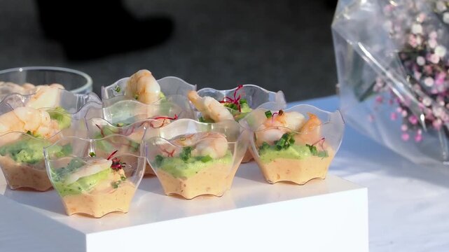 Verrines ap&eacute;ritives aux crevettes et cr&egrave;me d&rsquo;avocat pr&eacute;sent&eacute;es sur un buffet traiteur