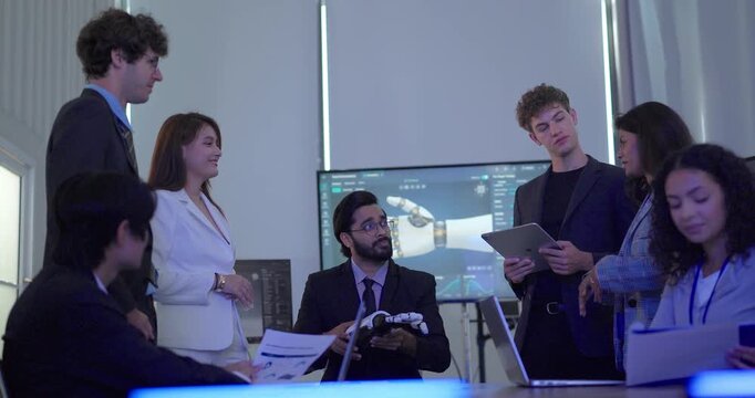Business team in suits inspecting robotic hand prototype at conference table in meeting room
