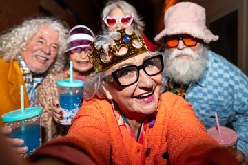 Group of happy senior friends with fancy clothing having party in the night