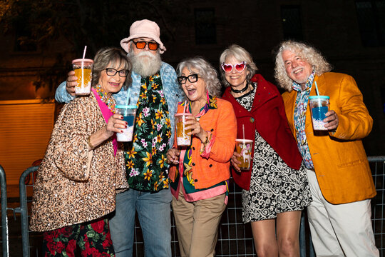 Group of happy senior friends with fancy clothing having party in the night