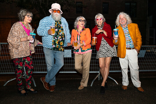 Group of happy senior friends with fancy clothing having party in the night