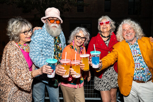 Group of happy senior friends with fancy clothing having party in the night