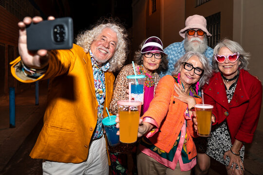 Group of happy senior friends with fancy clothing having party in the night