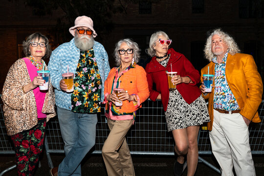 Group of happy senior friends with fancy clothing having party in the night