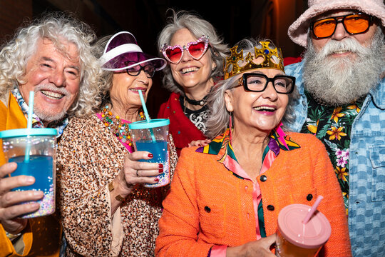 Group of happy senior friends with fancy clothing having party in the night