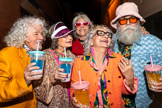 Group of happy senior friends with fancy clothing having party in the night