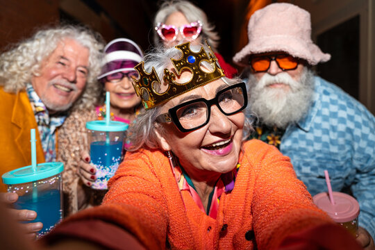 Group of happy senior friends with fancy clothing having party in the night