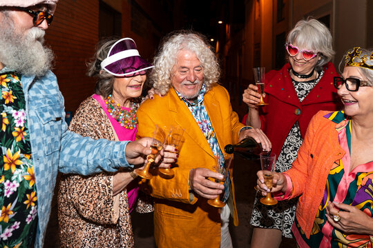 Group of happy senior friends with fancy clothing having party in the night