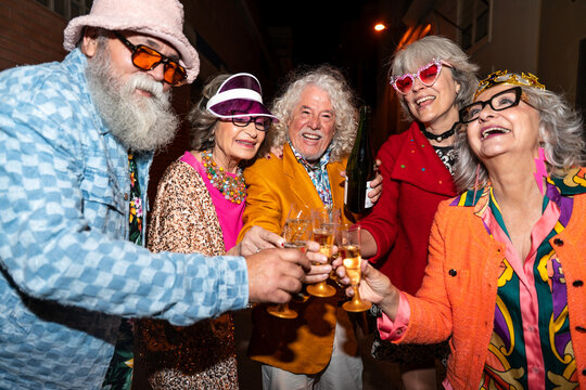 Group of happy senior friends with fancy clothing having party in the night