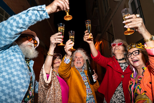 Group of happy senior friends with fancy clothing having party in the night