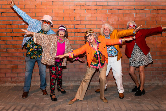 Group of happy senior friends with fancy clothing having party in the night