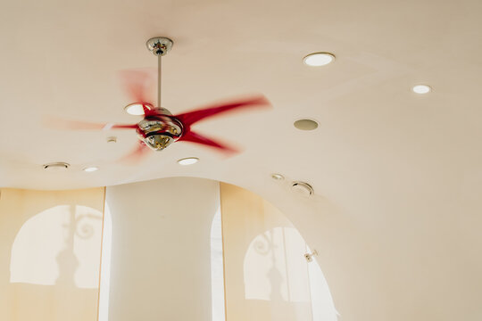 Ceiling fan spinning at high speed indoors during extreme summer heat, illustrating heatwave conditions, cooling, ventilation, energy use and climate adaptation.