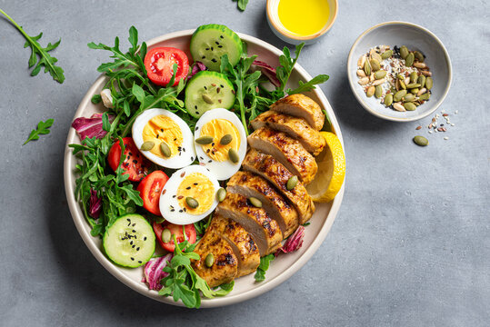 High protein lunch bowl with chicken, eggs and vegetable salad