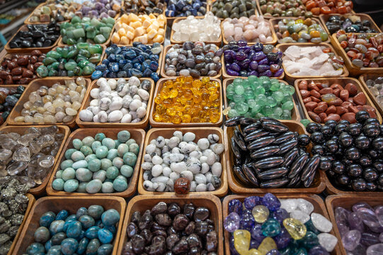 Istanbul,turkey,august 4, 2025. Assortment of polished natural gemstones and minerals showcasing vibrant colors and textures in small wooden bowls, for sale