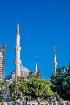 Istanbul,turkey,august 4, 2025. Sultan ahmed - blue - mosque with soaring minarets and majestic dome framed by green trees against a clear blue summer sky