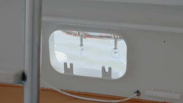 Ship deck mooring chock opening showing sea water surface and marine hardware details close up