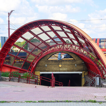 Staircase descent into underground pedestrian passage featuring striking red spherical dome ceiling, modern city urban architecture.