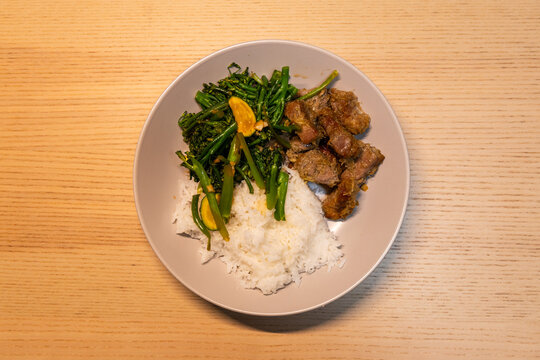 A plate of pork and vegetable with steam rice.
