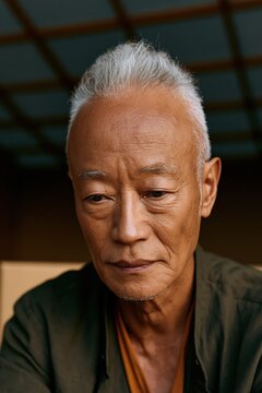 Senior man contemplative portrait opening a box for moving memory background and retirement care banner use
