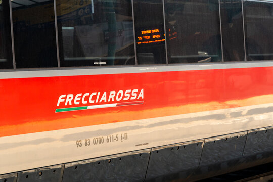Barletta, Italy - Aug 1, 2026: Frecciarossa lettering on the red band of a high speed train carriage with the vehicle number below and an orange digital display visible through the window