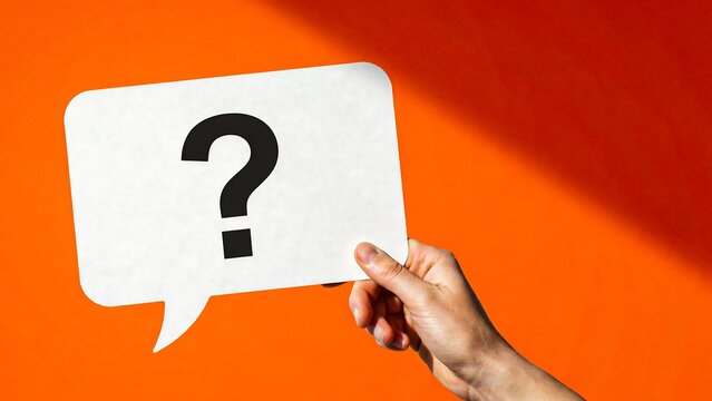 Hand holding a question mark speech bubble on a bright orange background