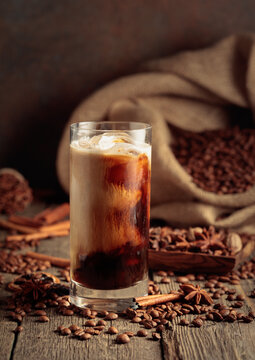 Iced coffee with cream on an old wooden table.