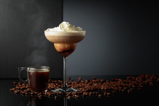 Black coffee and iced coffee cocktail on a black reflective background.