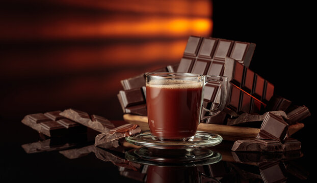 Mug of hot chocolate against broken bitter chocolate bars.