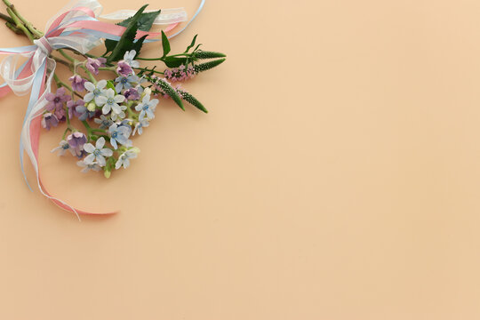 Top view image of romantic and delicate flowers on pastel background
