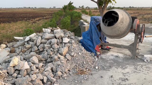 Concrete Mixer Machine and Stone Pile at Construction Site