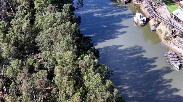 Banks of Murray river with paddle steamer boats at jetty Port of Echuca in Victoria, Australia.